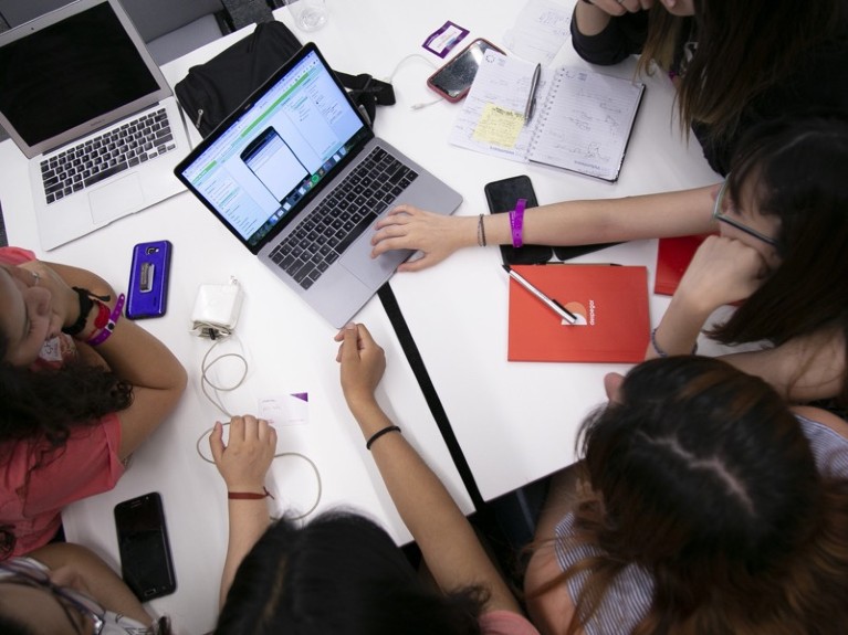 Girls work on a project on a laptop.