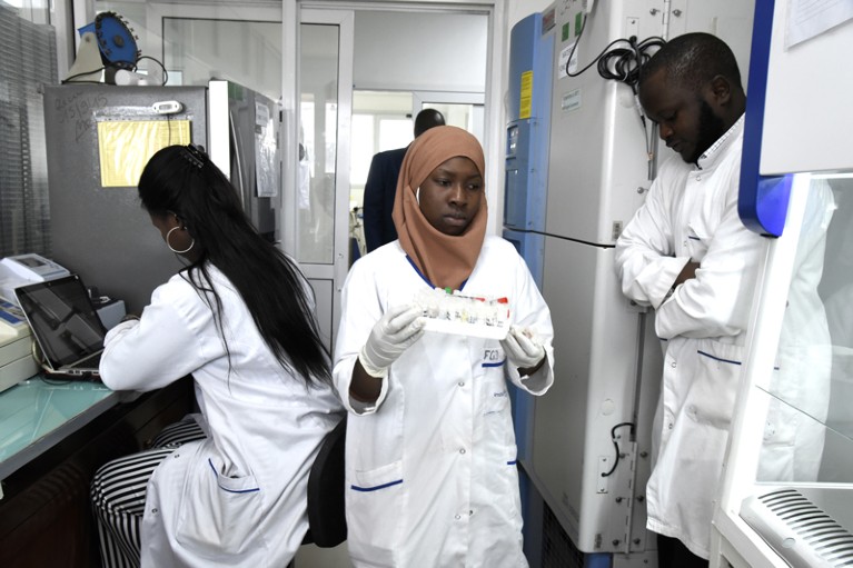 Scientific staff members works in a secure laboratory, researching the coronavirus, at the Pasteur Institute in Dakar