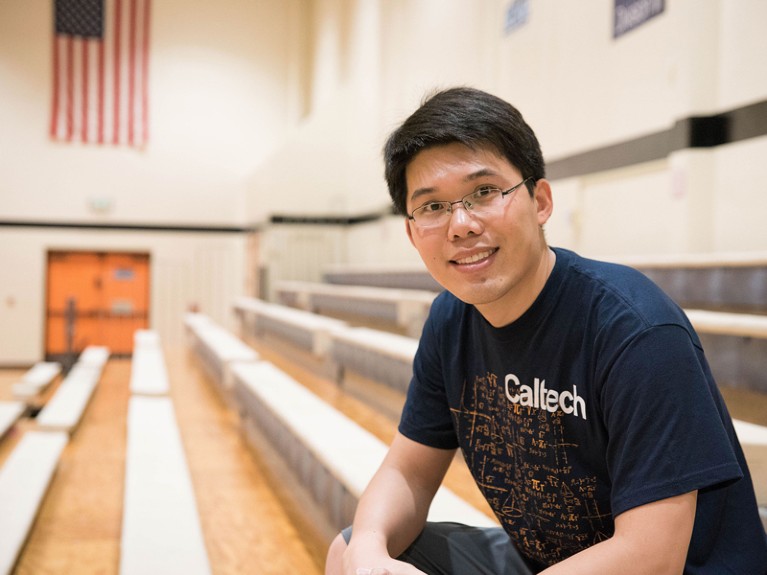 Wei Gao sits on the bleachers.