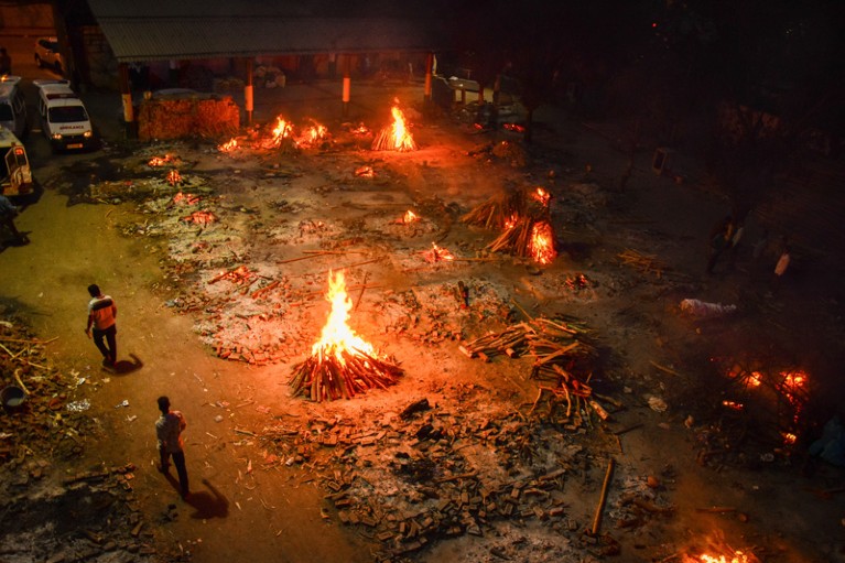 Multiple funeral pyres, seen from above at night.