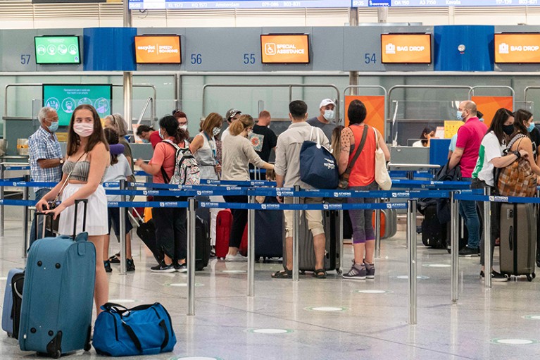 Passengers wearing face masks at the main departure hall in the terminal of Athens International Airport