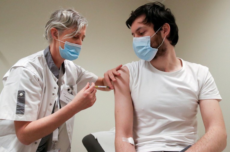 A volunteer is given an injection during CureVac clinical trial in Brussels, Belgium