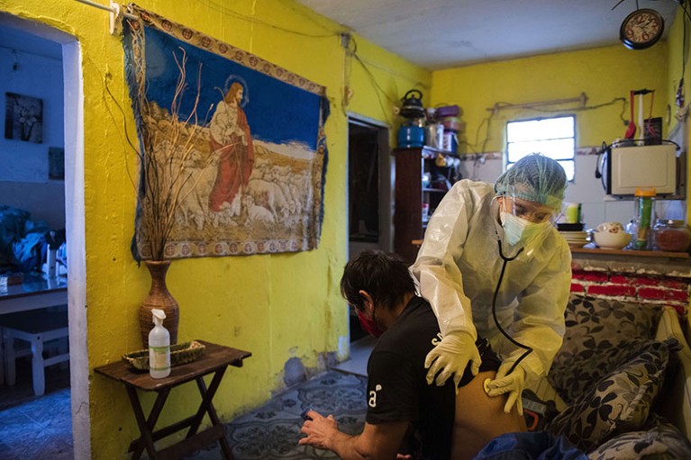 Doctor Carolina Moreira checks on COVID-19 patient Carlos Broll, 49, at his home in Montevideo, Uruguay.