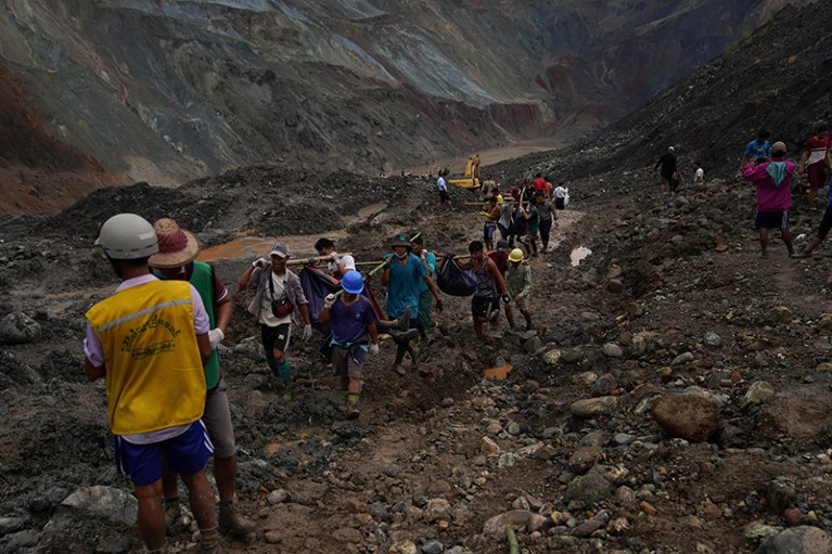 Rescuers recover bodies near the landslide area in the jade mining site in Hpakant in Kachin state on July 2, 2020.