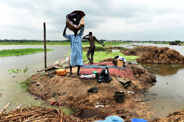A man carries a mattress salvaged from a home submerged by flood at Wawa along the Lagos–Ibadan expressway in Nigeria