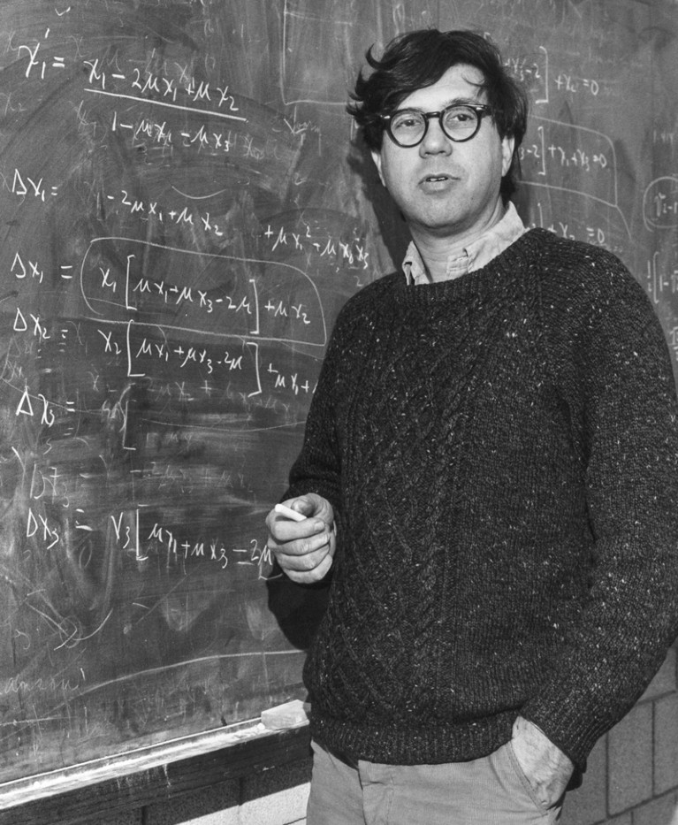 Black and white photo of Richard C. Lewontin standing at a chalk board