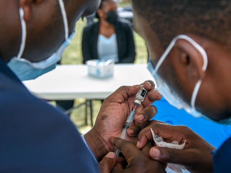 Health workers prepare a dose of the J&J vaccine during a mass vaccination campaign against the Covid-19, in Tanzania.