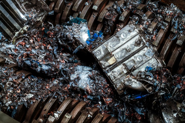 An electric car battery module entering a battery shredder with powerful metal teeth