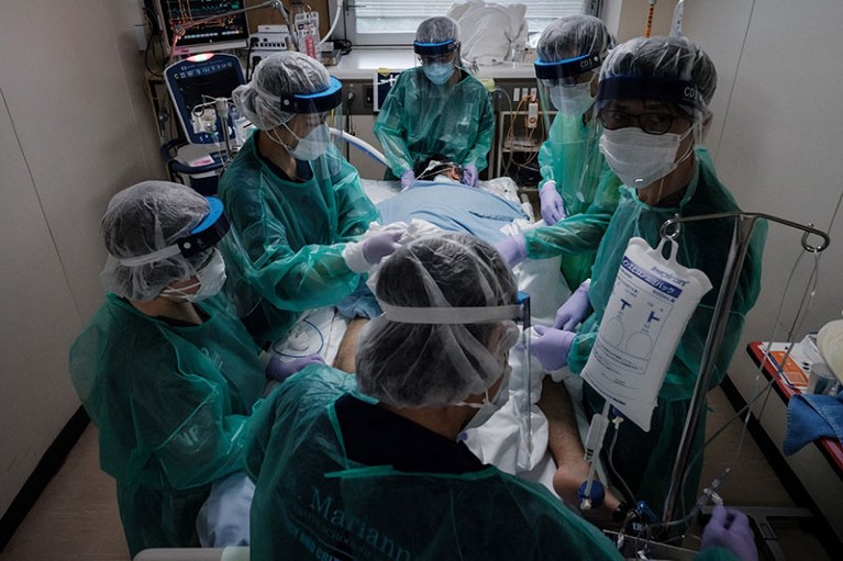Medical workers in protective equipment take care of a COVID-19 patient on a ventilator at Yokohama City Seibu Hospital.