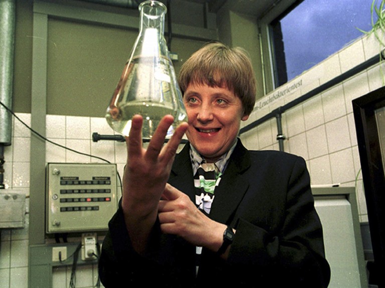 Federal Minister Merkel is holding up a test tube filled with water, January 1995.