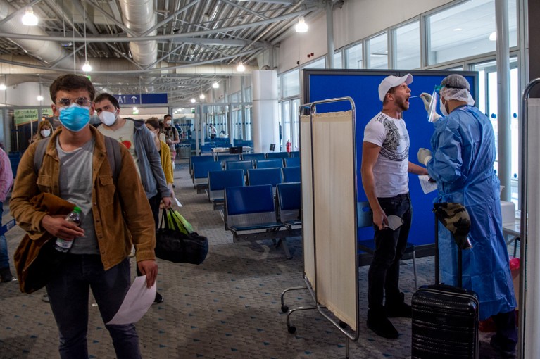 A member of medical staff performs a COVID test on a passenger in Athens airport