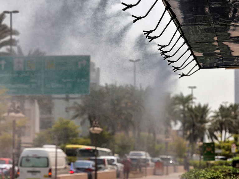 Sprinklers release water vapour along a street in Dubai on 25 August 2021 to relieve pedestrians amid a heatwave.