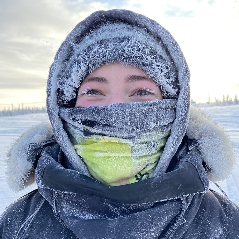 Erica Gillis in the subarctic ice area with ice and frost on her face and clothing.
