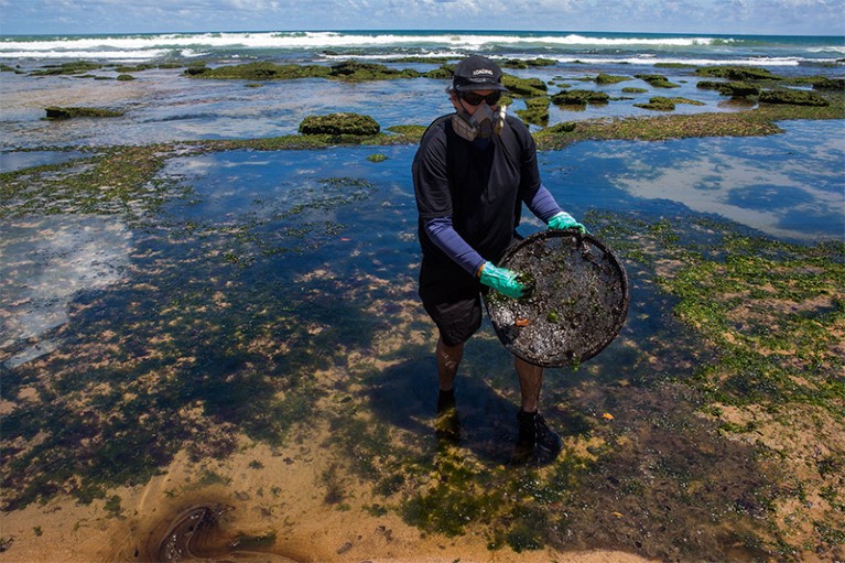 A volunteer cleans oil at a beach in Lauro de Freitas, Bahia state, Brazil, on November 2, 2019