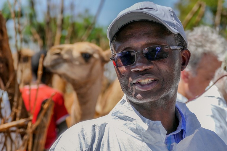 Kariuki Njenga standing in front of a camel