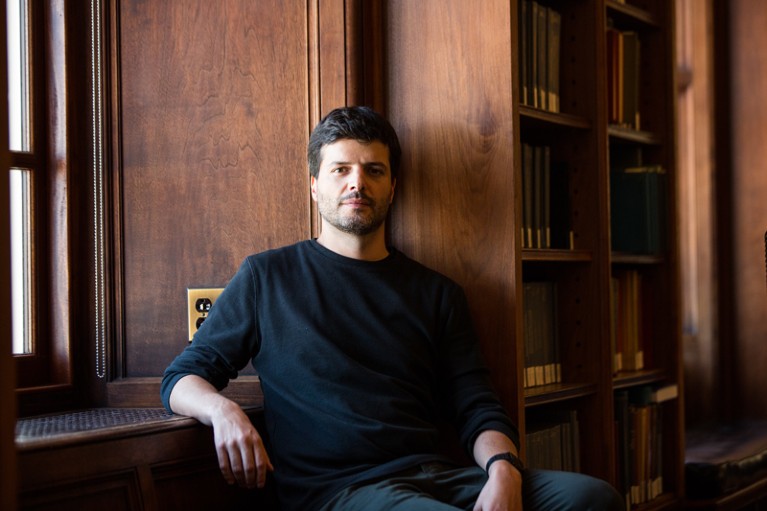 Portrait of Gabriel Victora sitting by a window in a library