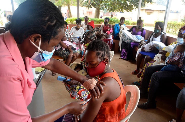 A nurse injects a woman with the Hepatitis B vaccine at a health center in Uganda.