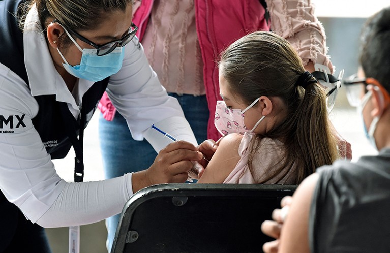 A minor is inoculated with the first dose of the Pfizer-BioNtech COVID-19 vaccine in a Mexico City library.