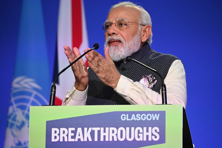 Narendra Modi gestures while standing at a podium.