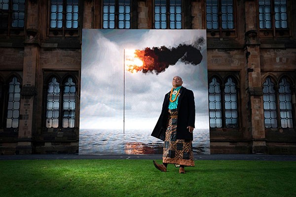Tongan activist Uili Lousi stands alongside 'Flare Oceania 2021' by artist John Gerrard.