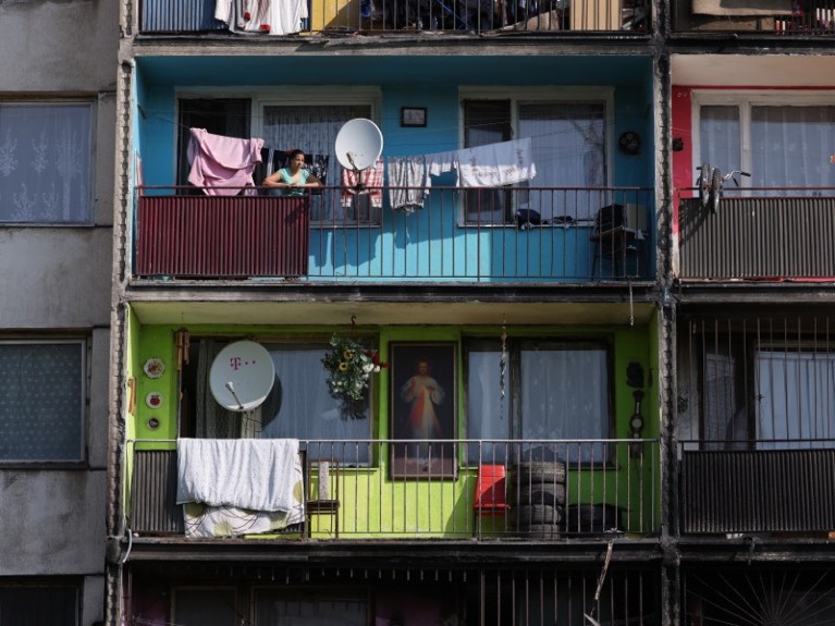 A Roma resident looks out from the balcony of an apartment building in Slovakia.