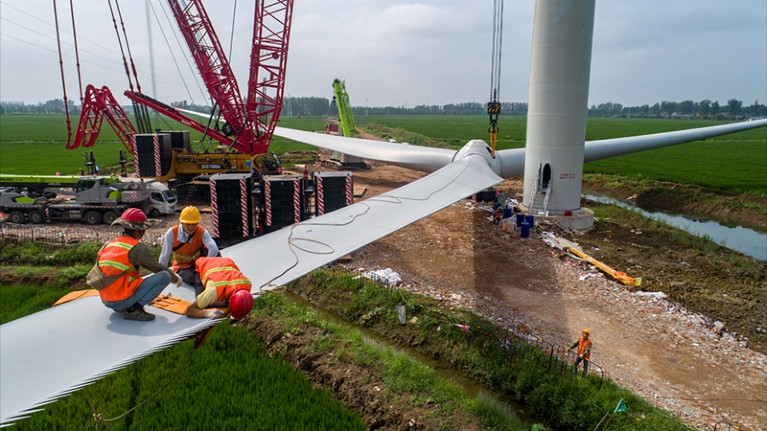 Workers fasten wind turbine blades before are hoisted into position in Huai'an, Jiangsu Province of China.