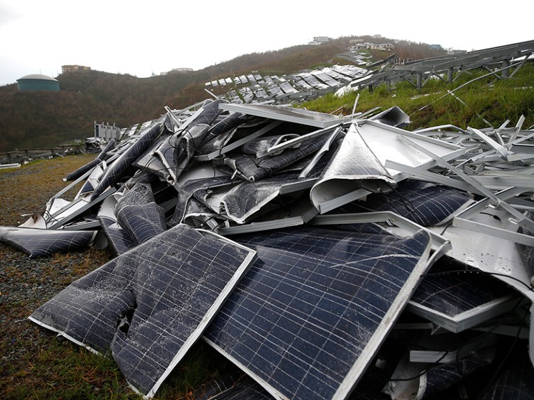 Twisted solar panels lie in a heap on the ground
