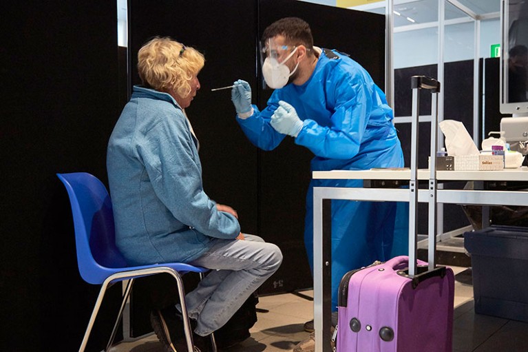A passenger of a flight from South Africa is tested for the Coronavirus at Amsterdam Schiphol airport.