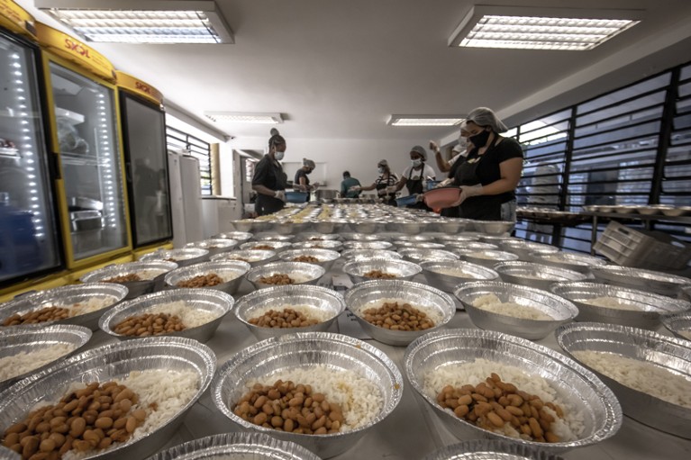 Volunteers prepare meals for aid distribution at the Paraisopolis favela in Sao Paulo