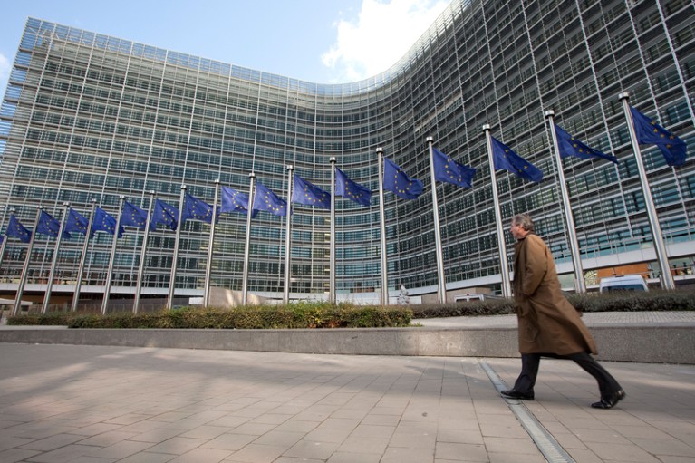 A man walks next to the European flags outside the European Commission headquarters in Brussels