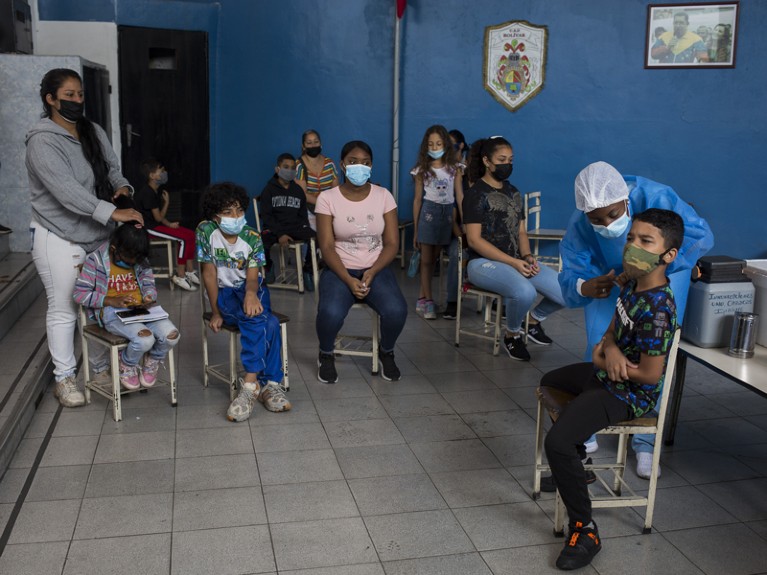 Students, who are accompanied by their mother, wait to be vaccinated against Covid-19 in Caracas, Venezuela.