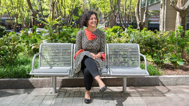 Neha Kumar sits on a bench outside the Georgia Tech School of Interactive Computing.