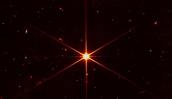 A six-pointed star shines red in front of the blackness of space.
