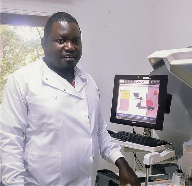 Louis Banda stands by some equipment in the lab