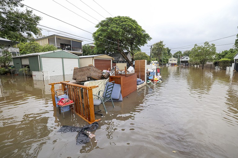 2022年3月3日，澳大利亚布里斯班一条被洪水淹没的道路上堆满了垃圾和损坏的家具。