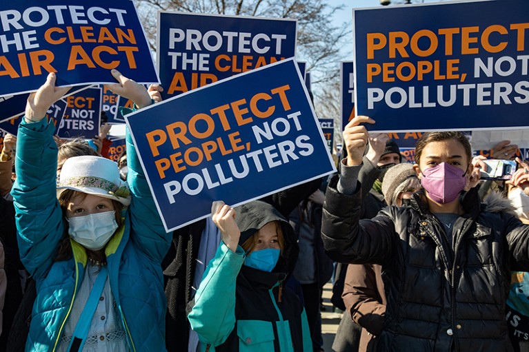 Climate change activists hold signs outside of the Supreme Court in Washington, D.C., U.S., in support of the Clean Air Act.