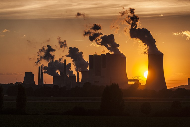 The sun sets behind the cooling towers of Neurath lignite-fired power station in Neurath, Germany.