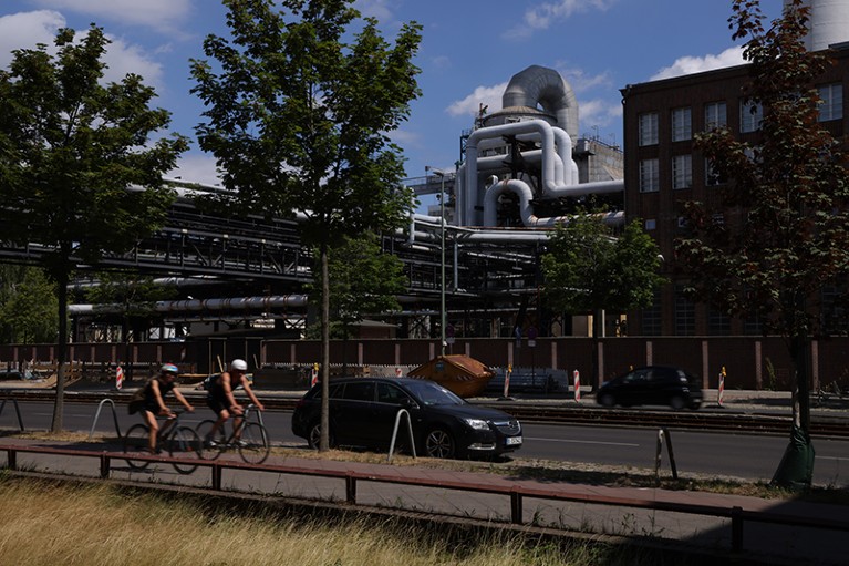 Bicyclists ride past the Klingenberg natural gas-powered thermal power station in Berlin