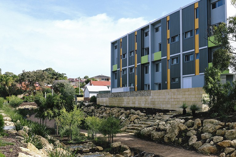 A drainage sump in shown in the foreground, to the left of a residential building in White Gum Valley, Perth