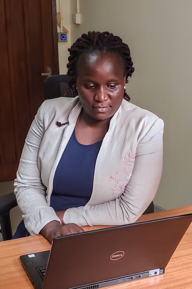 Mary Nyantaro working on a laptop in an office