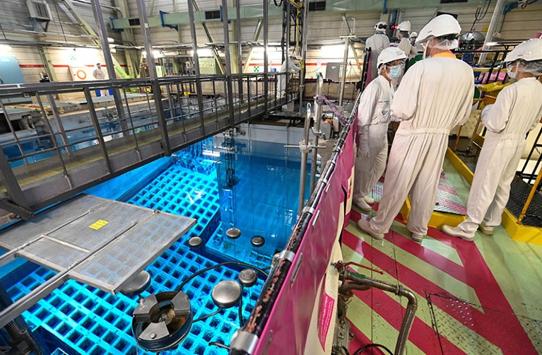 一群法国电力公司的员工在Fessenheim核电站的存储池旁，法国。