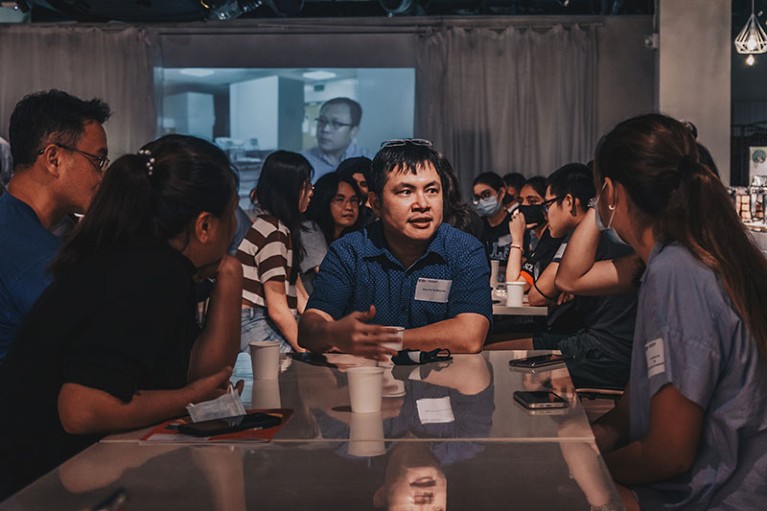 Meng How Tan sits with Nanyang Technological University applicants at a tea party.