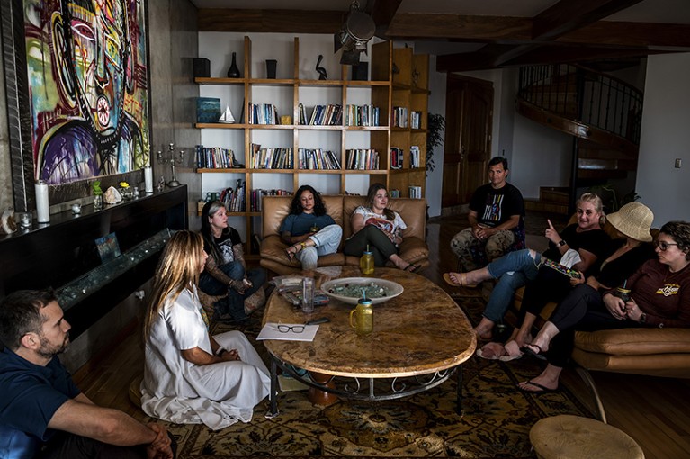 A group of men and women sit around a large table in a bright room at psychedelic retreat in Mexico