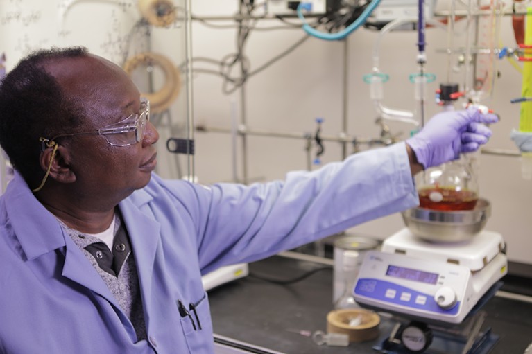 Robert Kargbo adjusts chemistry equipment in the Usona laboratories