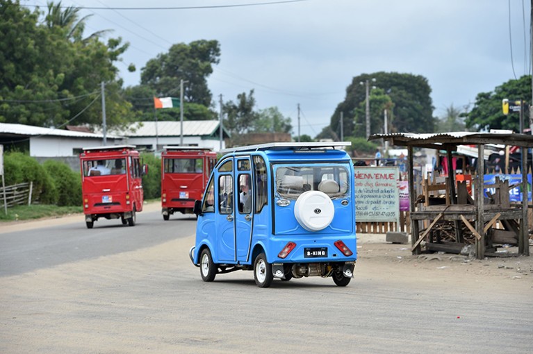 Electric three-wheeler taxis with solar panels on the roof are driven in Ivory Coast's coastal city of Jacqueville.