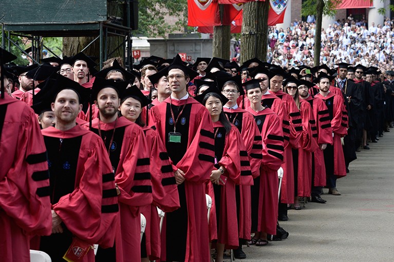 People in traditional robes sit at the Harvard University 2015 Commencement at Harvard University in Cambridge, Massachusetts.