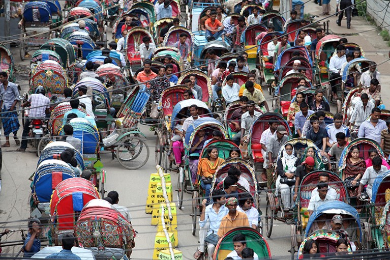 Rickshaw pullers transporting their customers into the traffic in Bangladesh on Ramadan.
