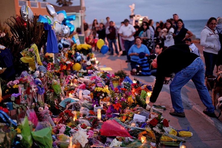 A group of people pay their respects to Junior Seau at a makeshift memorial outside of his home in Oceanside, California, U.S.