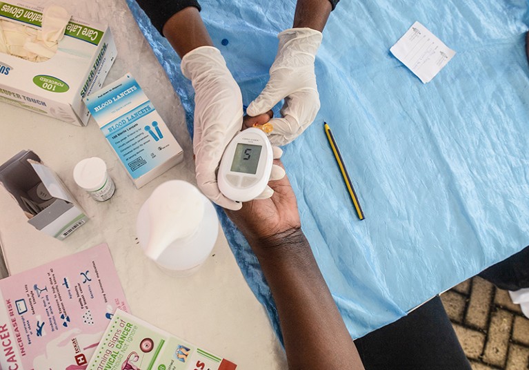 A nurse taking a blood test on a patient using the CERA-CHEK Hb Plus