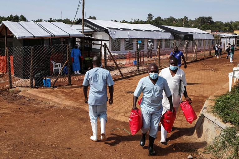 Medical attendants with red bag outside the Ebola isolation section of Mubende Regional Referral Hospital, in Mubende, Uganda.